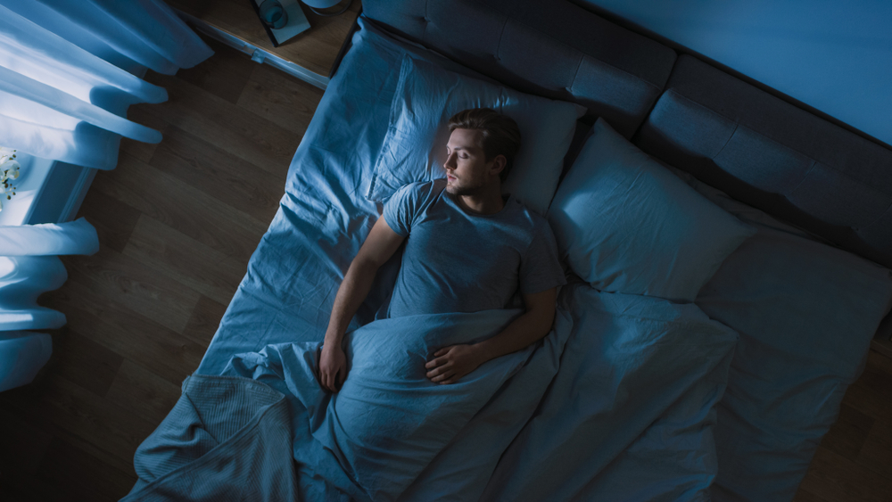 Young Man Sleeping Cozily on a Bed in His Bedroom