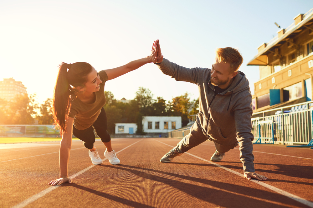 Young couple doing pushups in the stadium