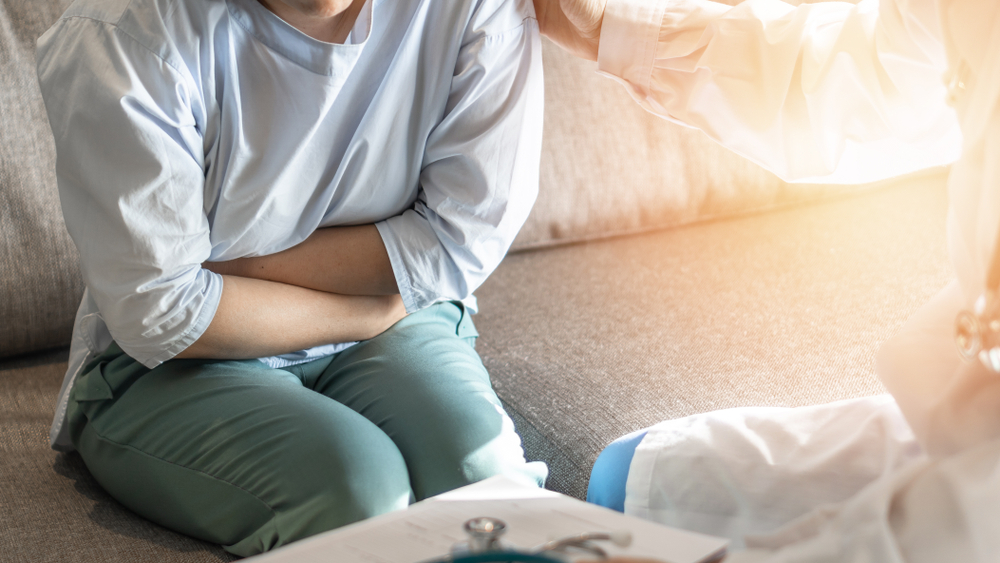 Abdominal pain patient woman having medical exam with doctor on illness from stomach