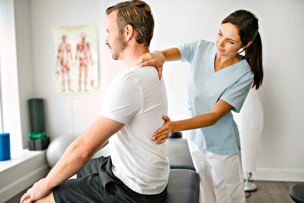 A physiotherapist doing treatment with patient in bright office