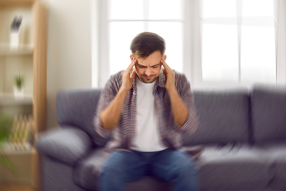 Young guy feeling pain and spinning sensation in his head.