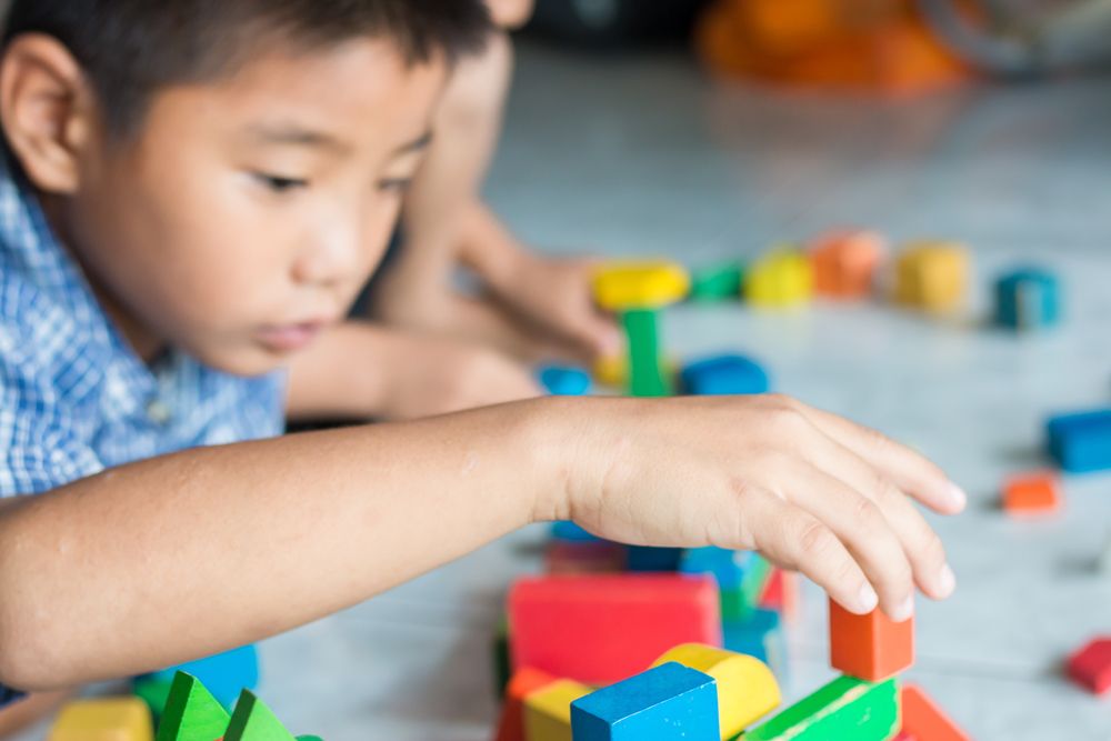 A child playing with blocks to practice motor skills for their Developmental delays