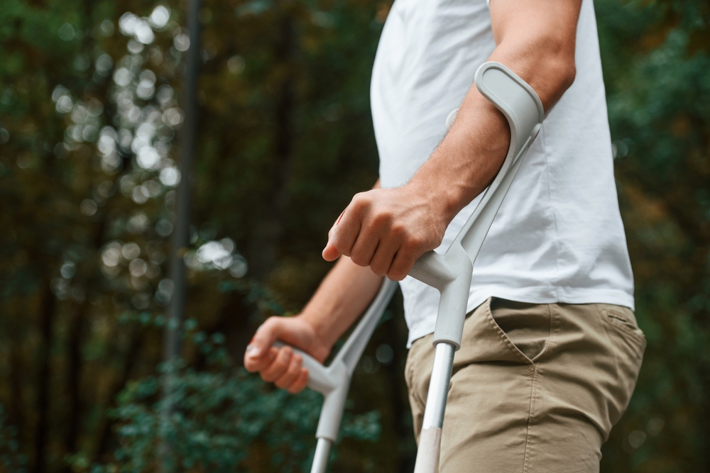 A man using crutches to walk with his Multiple Sclerosis