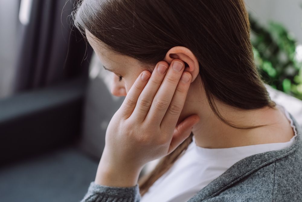 Woman holding her ear after feeling dizzy