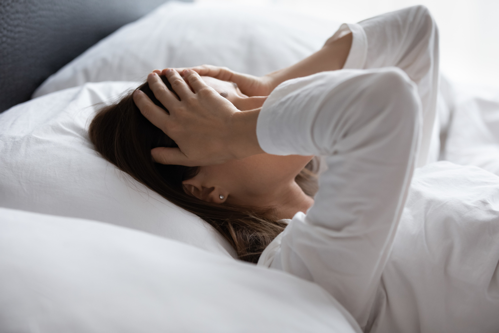 Woman lying in bed experiencing dizziness