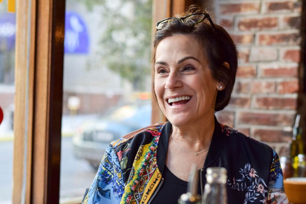 Beautiful and stylish middle aged woman laughing at a restaurant