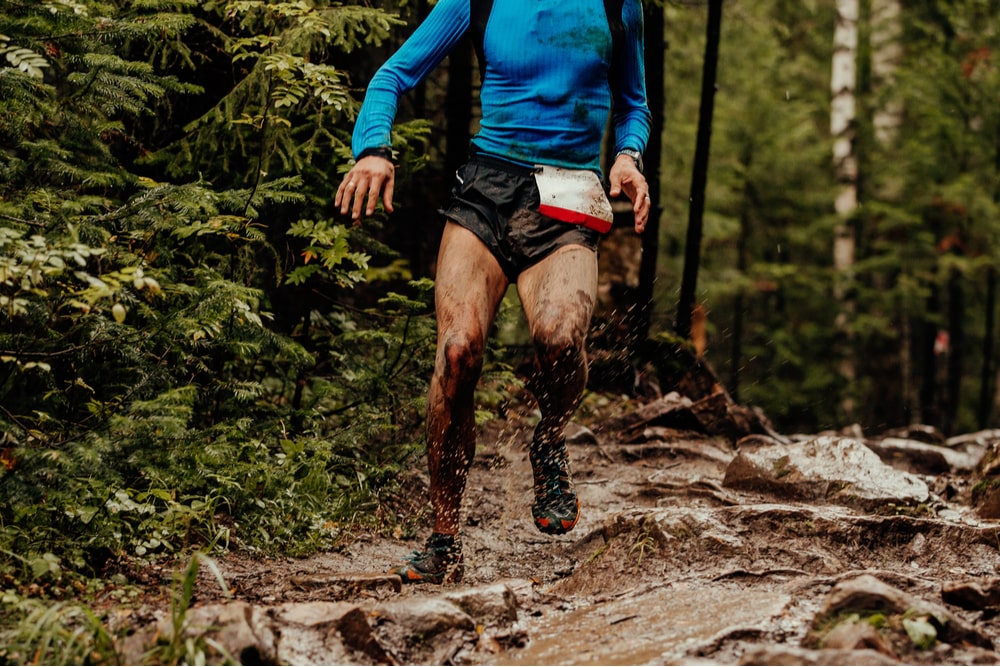 dirty athlete runner running puddles with mud splashing water