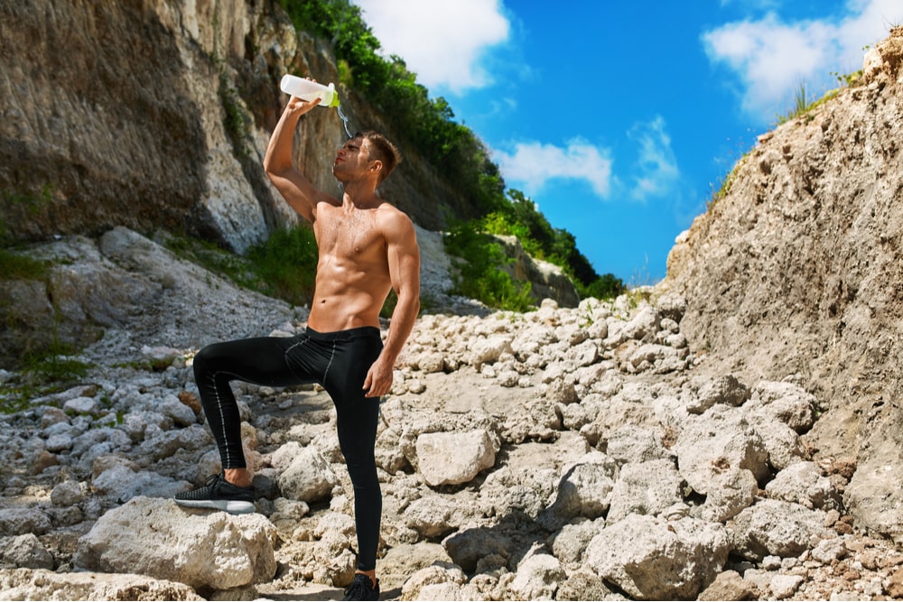 Tired Athletic Man With Muscular Body Pouring Water Over Face, Resting After Running Workout