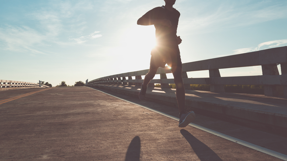 The man with runner on the street be running for exercise.