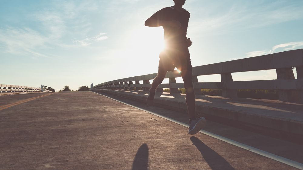 The man with runner on the street be running for exercise.