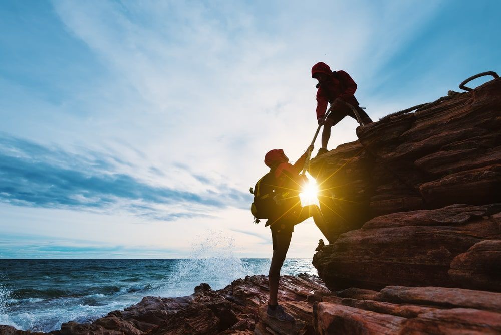 Young couple climbing up on the mountain