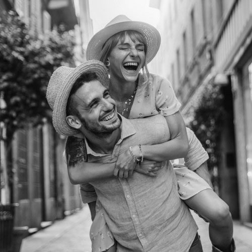 Couple of tourists having fun walking on city street at holiday