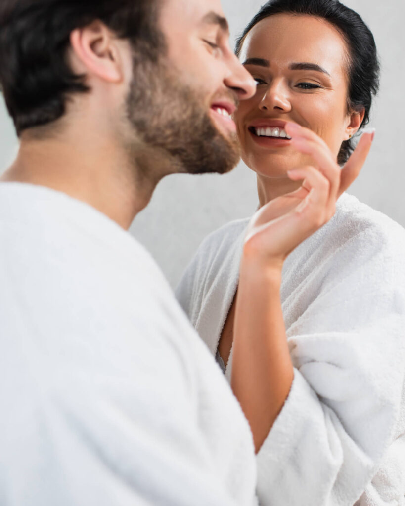 cheerful woman applying face cream