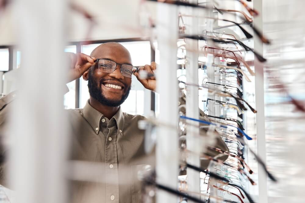 Shot of a young man buying a new pair of glasses