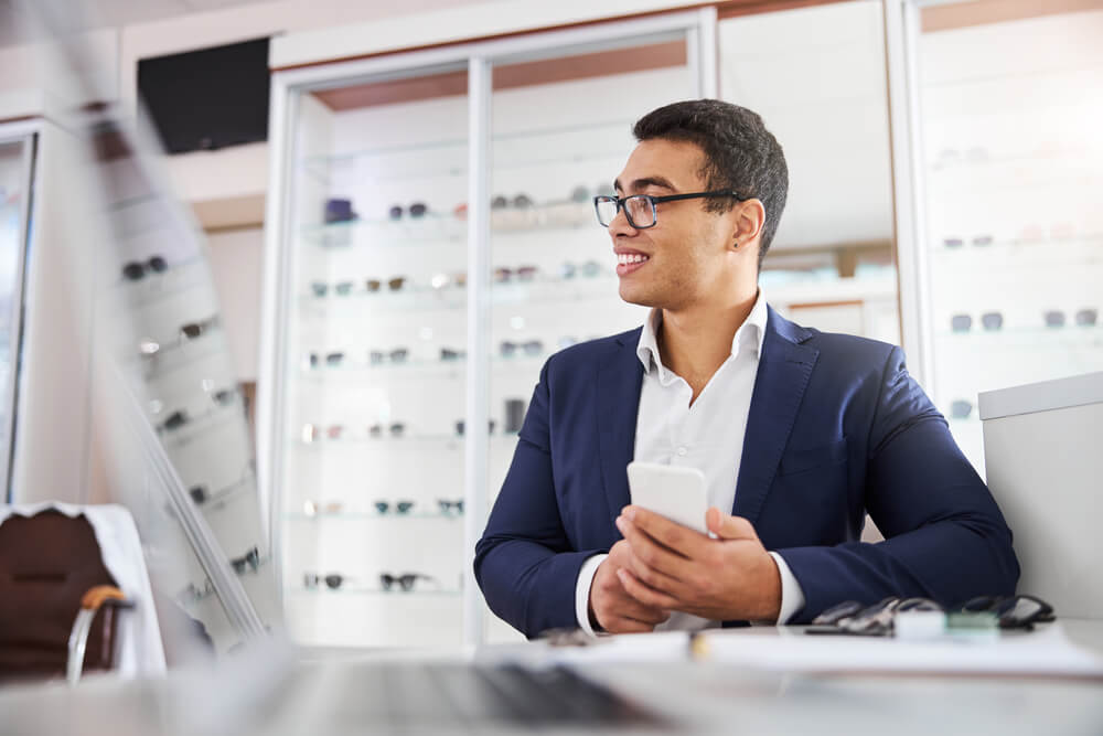 Smiling good-humored attractive young man in eyeglasses