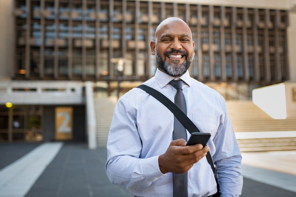 Smiling mature man holding cellphone