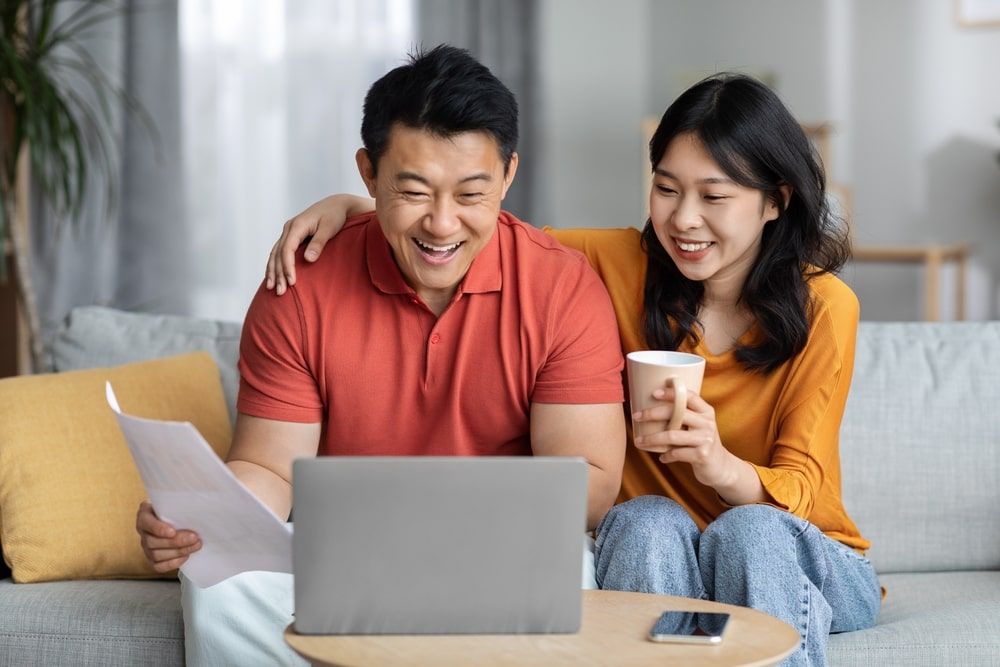 Happy man holding papers and Using laptop, cheerful woman drinking tea