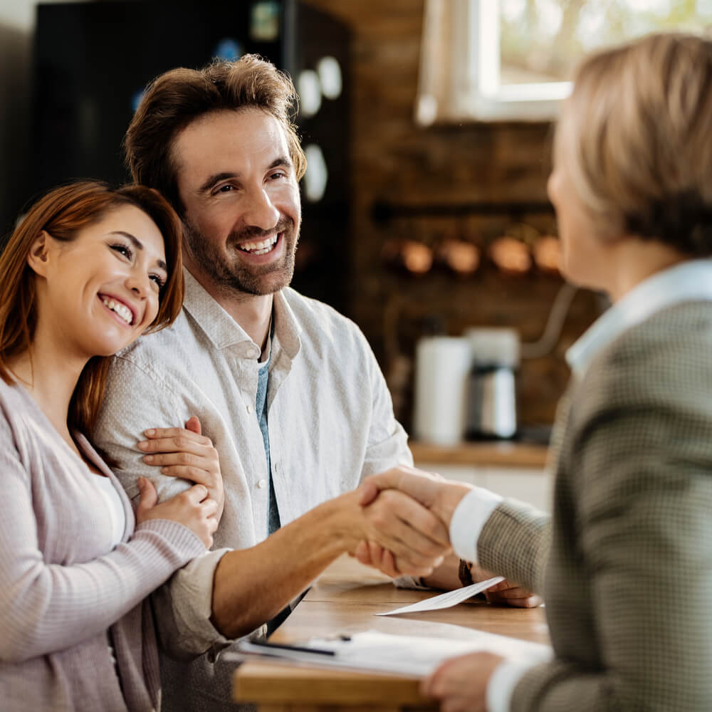 Young happy couple came to an agreement with their insurance agent.