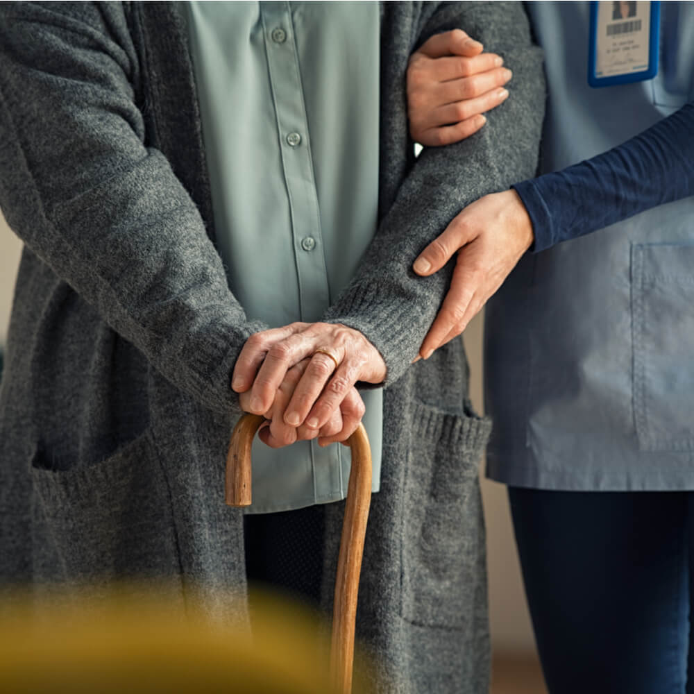 Close up hands of caregiver doctor helping old woman