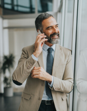 Handsome mature businessman with mobile phone in the office