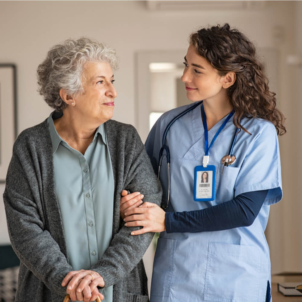 Young caregiver helping senior woman walking