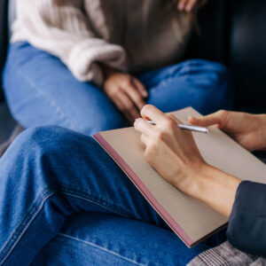 Close-up of a psychologist's hands writing down notes