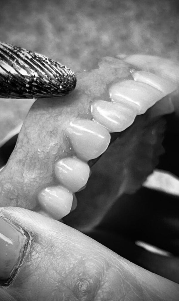 Dental technician doing final touches on full dentures