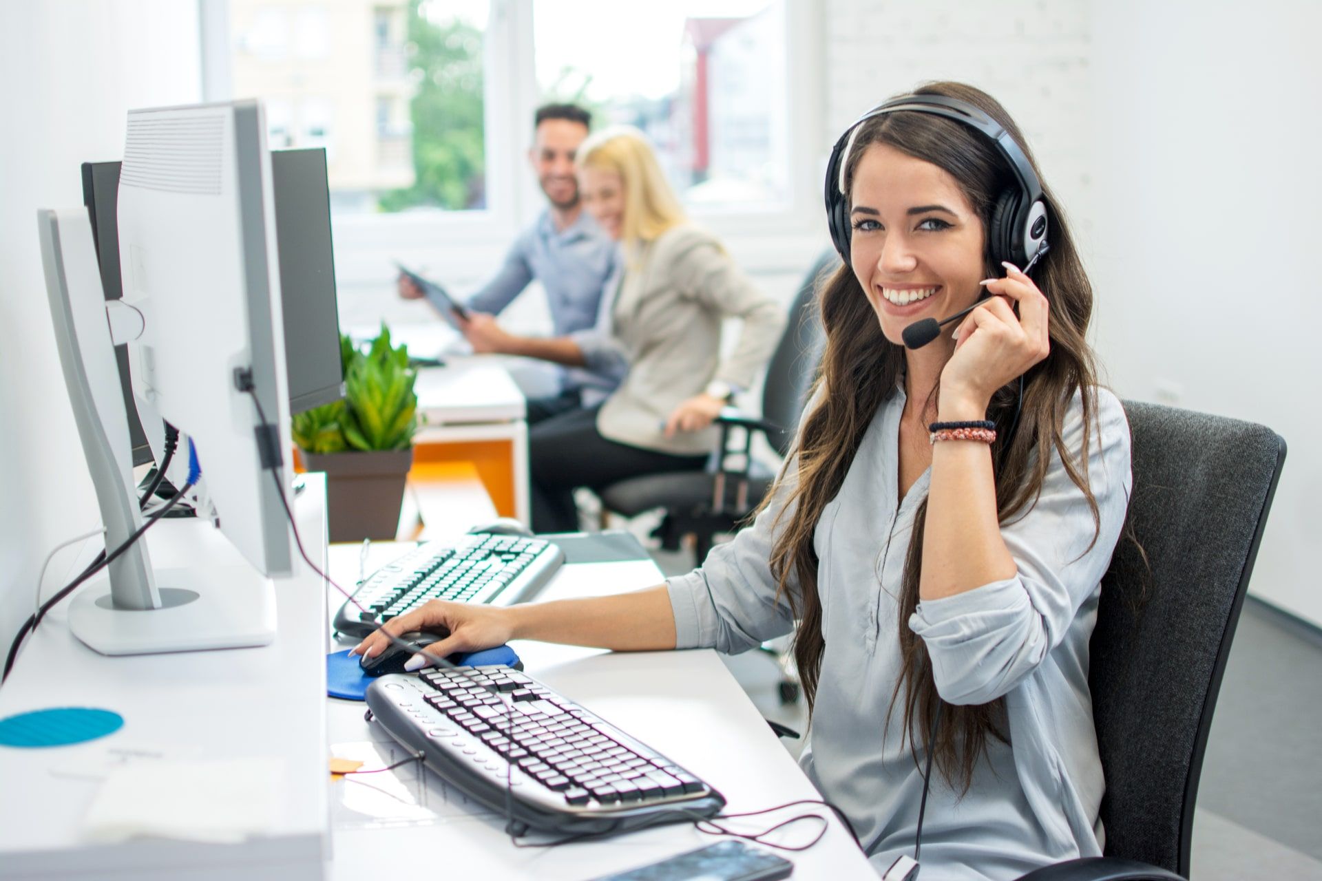 Smiling friendly female call-center agent with headset