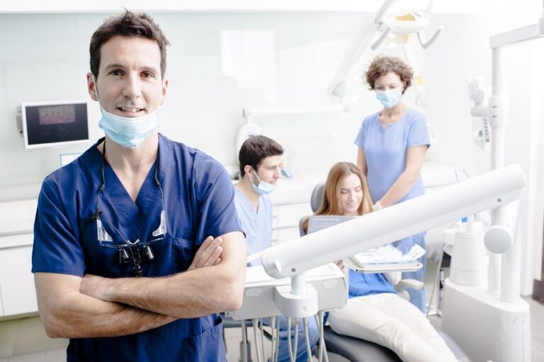 Dentist with his team working in the background