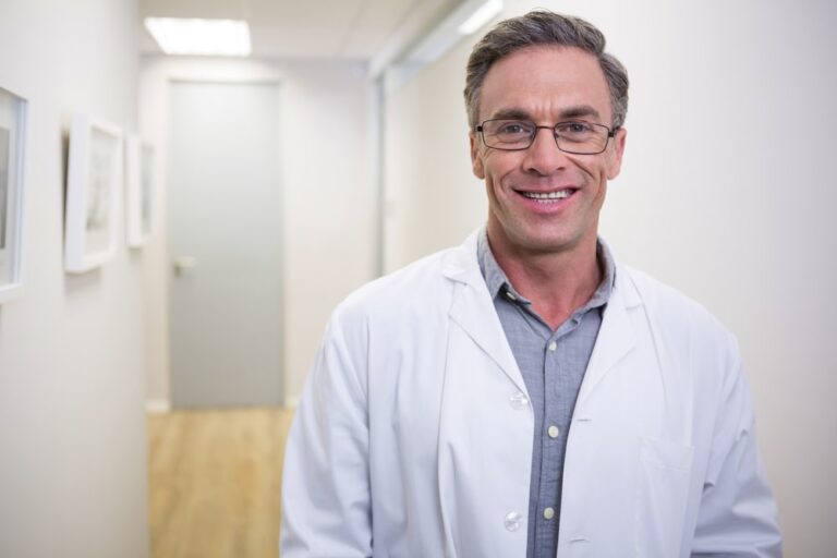 smiling dentist standing at lobby in dental clinic