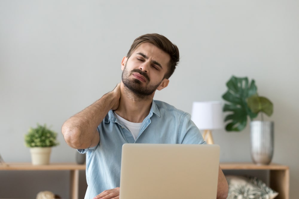 Millennial tired stressed man having a neck pain