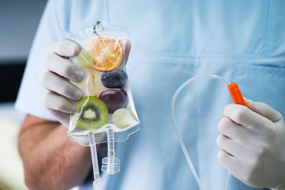 Male Doctor Holding Saline Bag With Fruit Slices Inside In Hospital