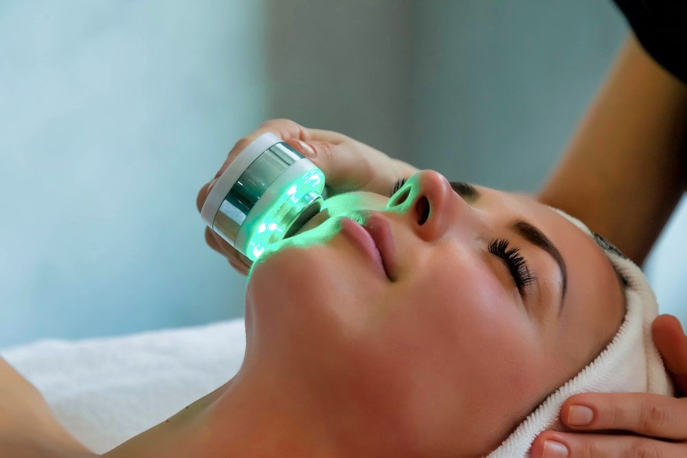 Beautician doing led light therapy to woman in SPA