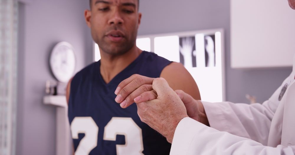 Basketball player with sports injury being examined by doctor.