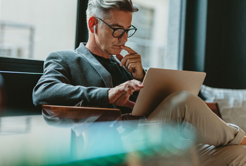 Businessman looking at laptop and thinking