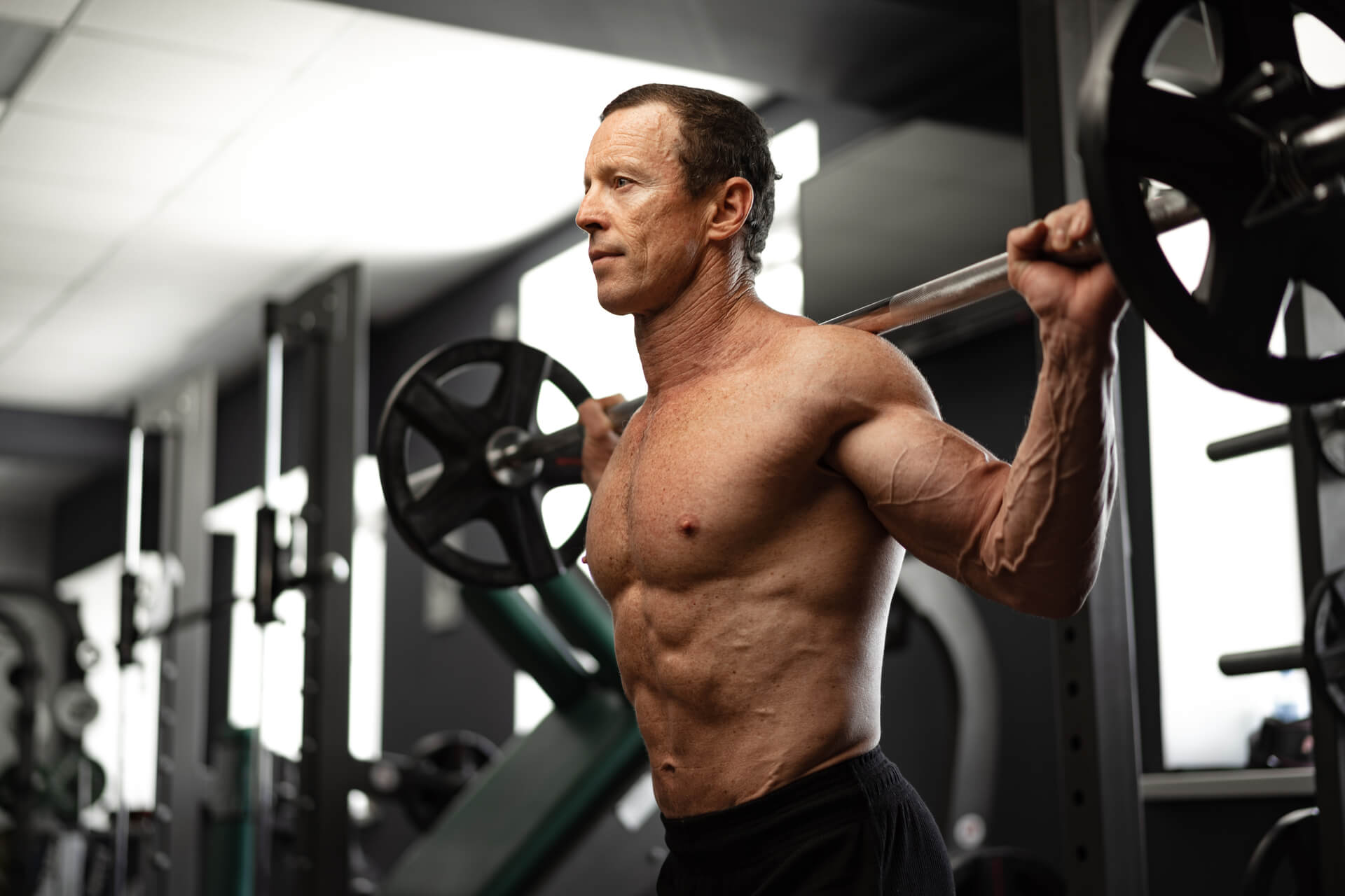 Senior man working out at the gym doing squats