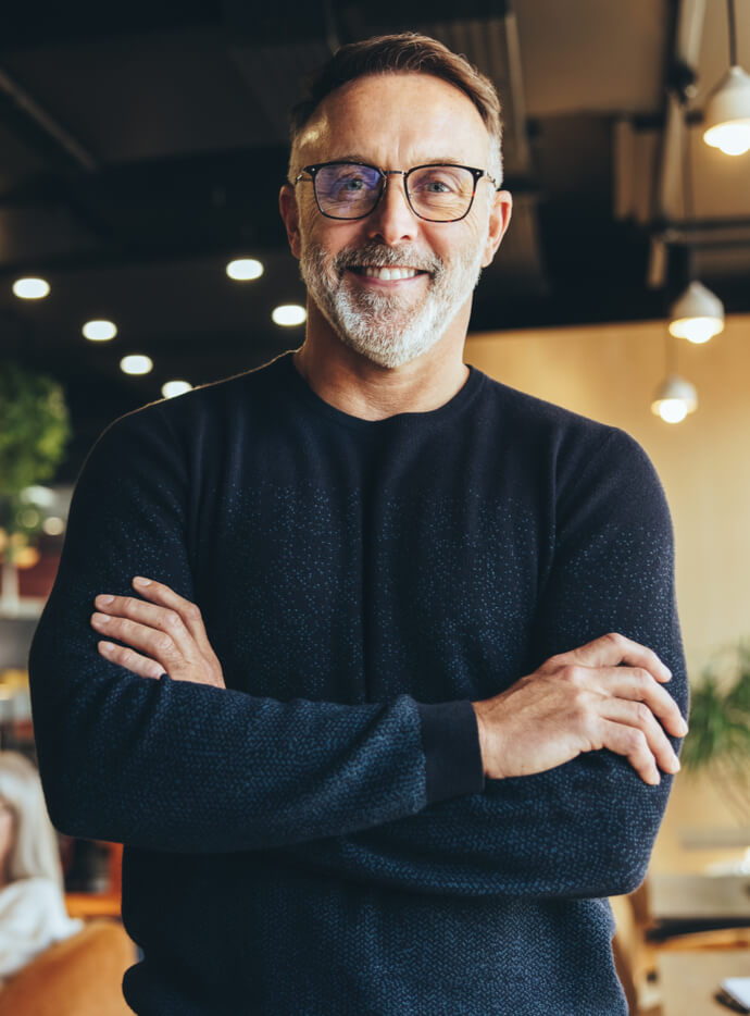 Mature businessman standing in a co-working space.