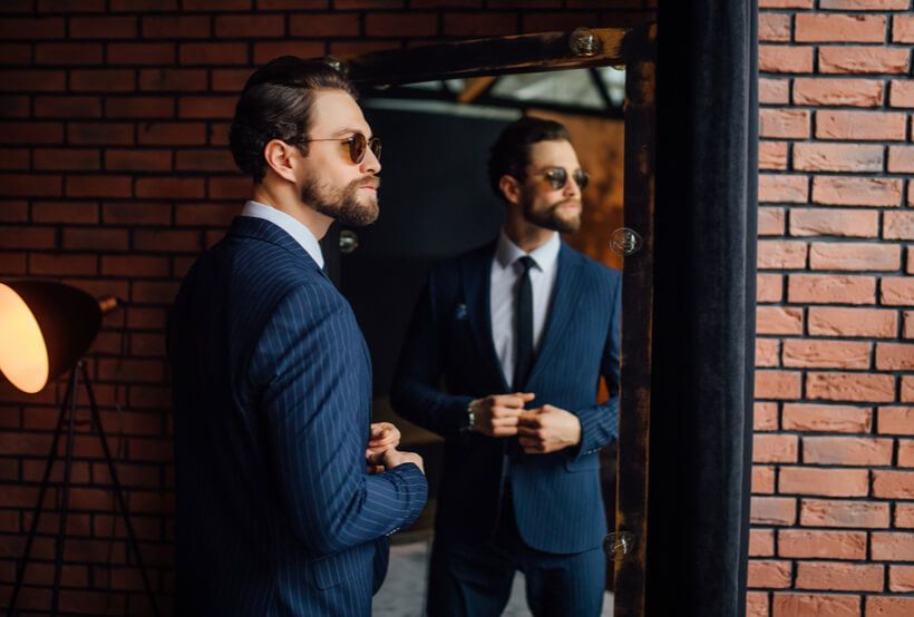 elegant young man choosing and trying suit