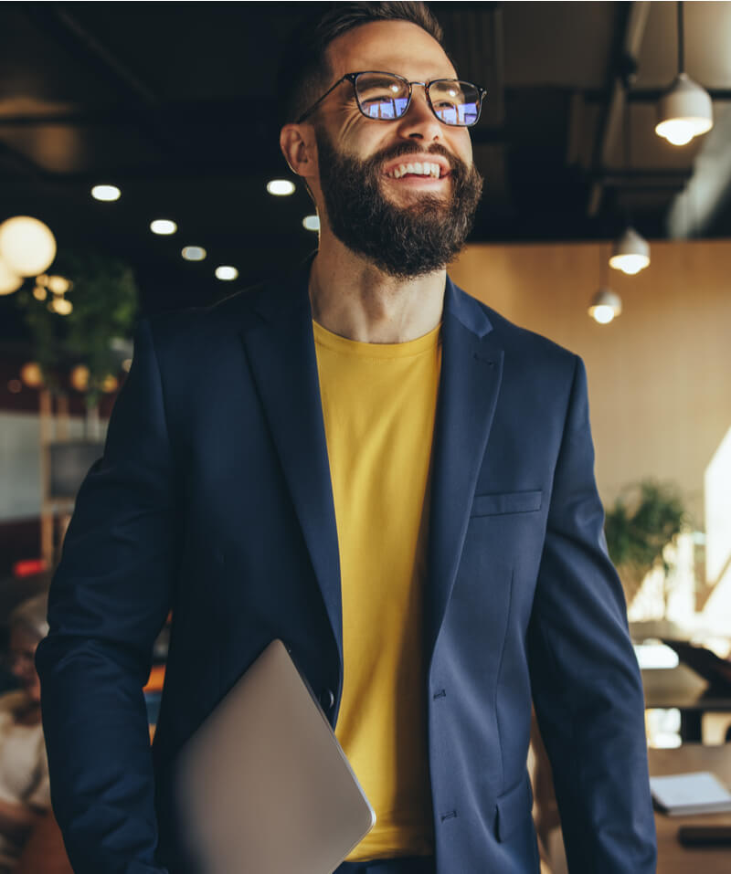 Happy young businessman smiling in a co-working space