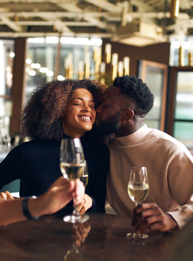 Man kissing woman in wine bar