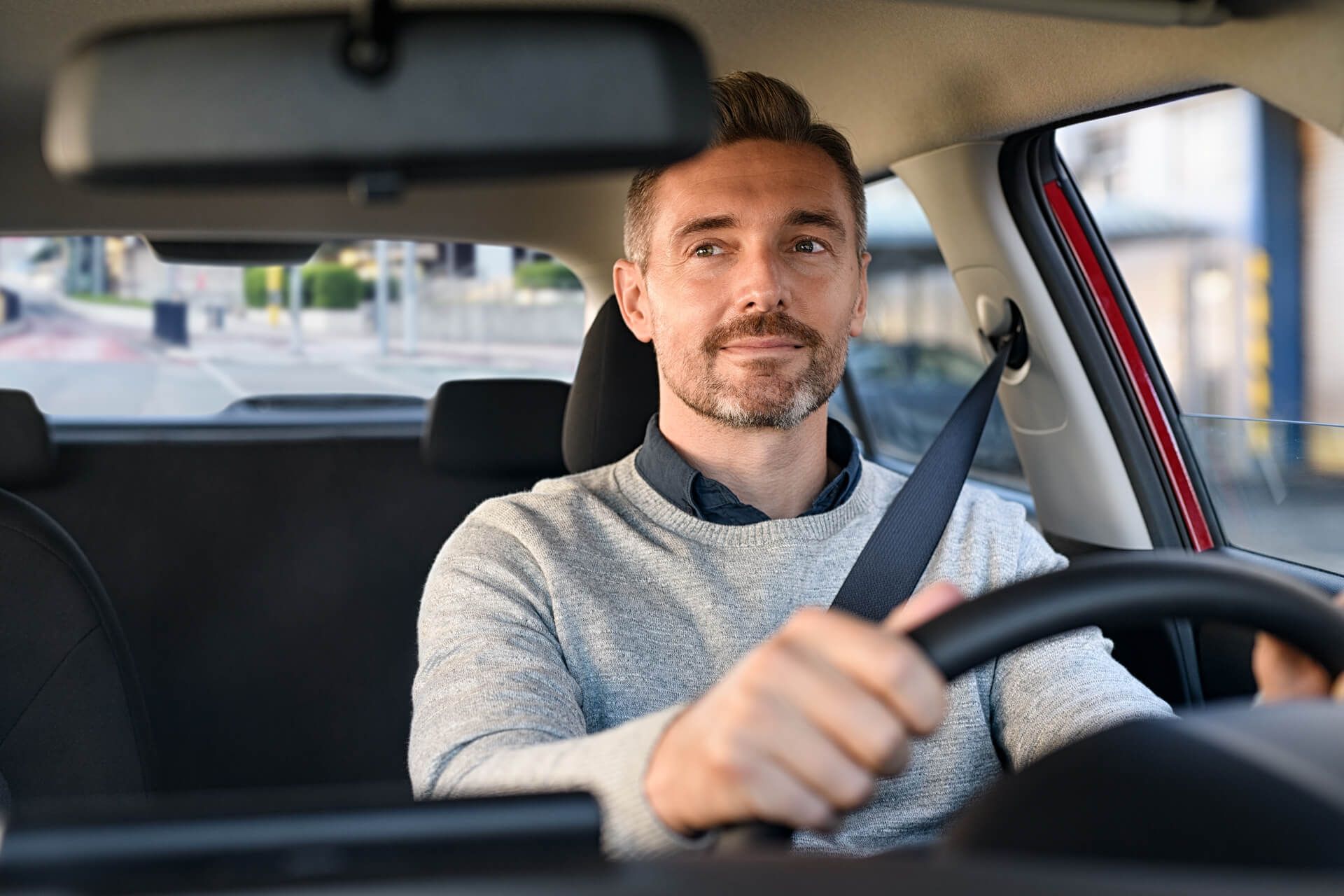Mid adult man smiling while driving car