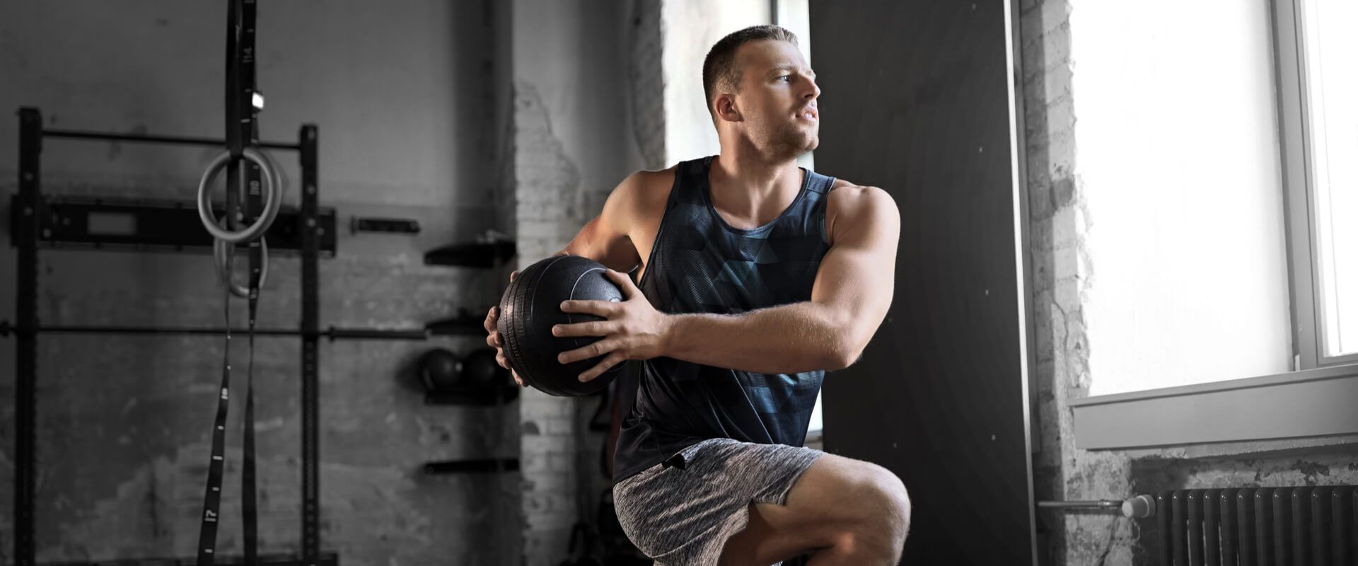 young man exercising with medicine ball in gym