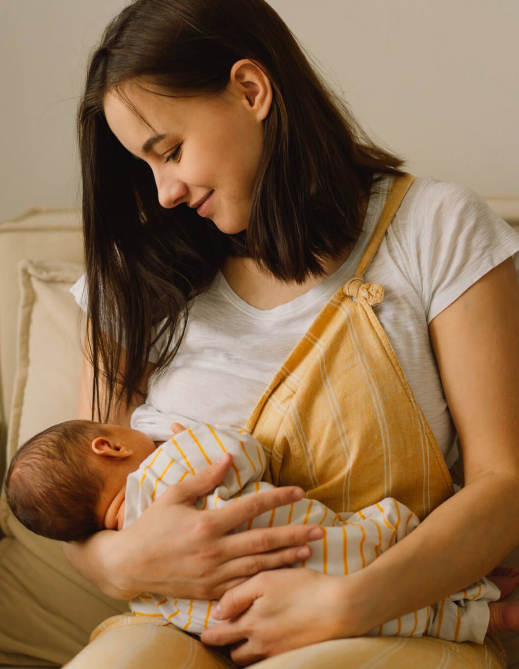 Newborn baby boy sucking milk from mothers breast.