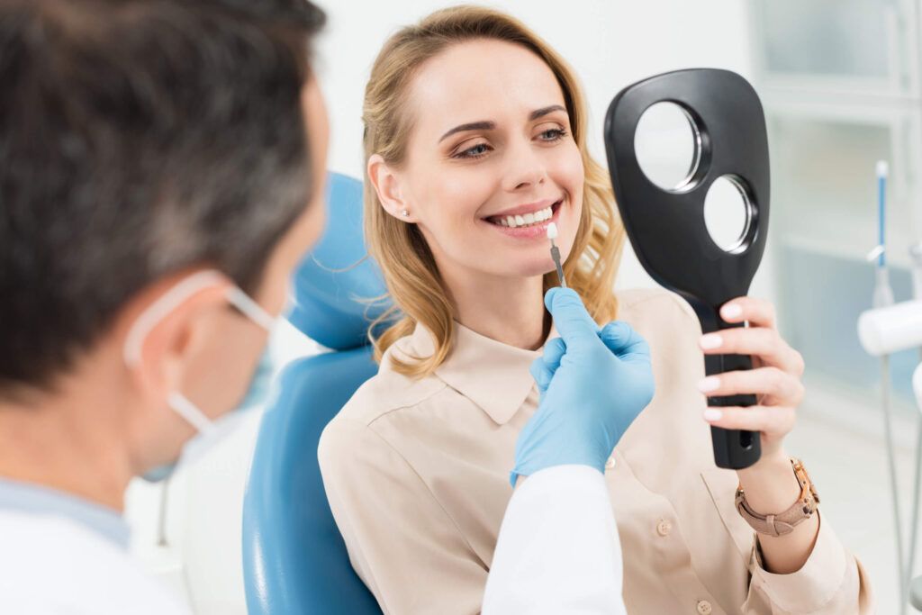 Female patient choosing tooth implant looking at mirror