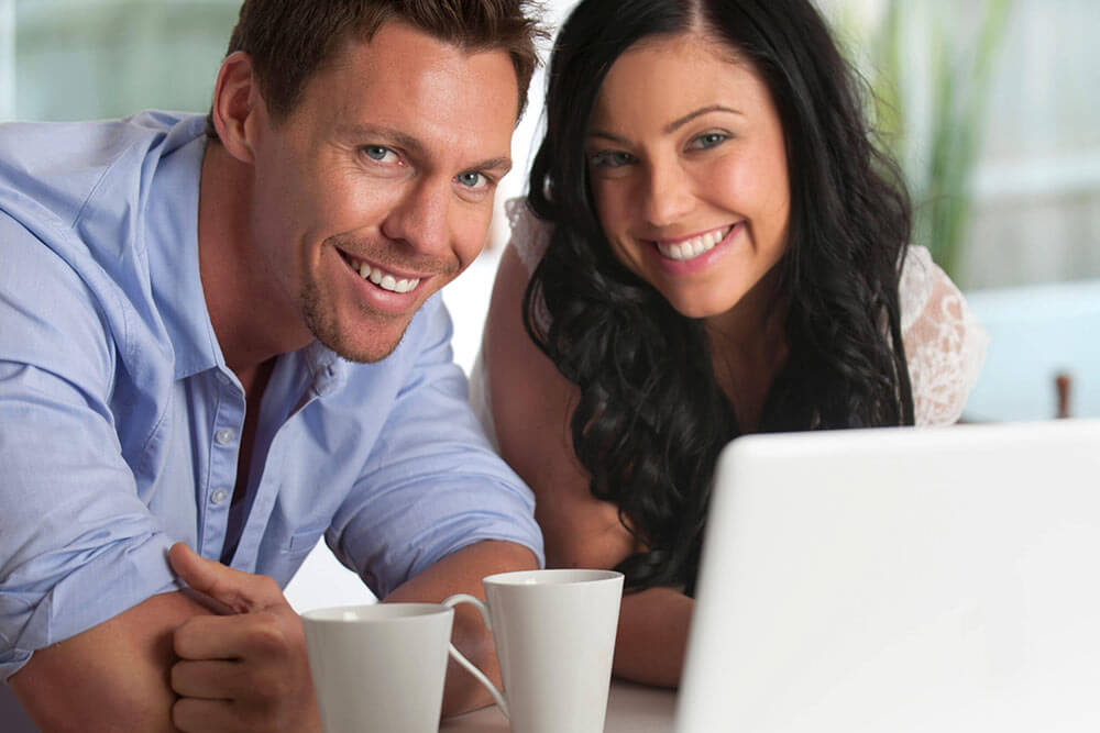 Smiling Couple looking at laptop together