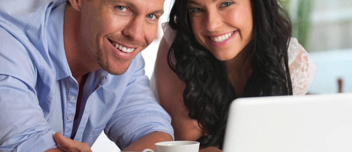 Smiling Couple looking at laptop together