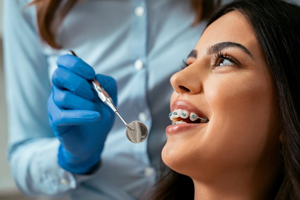 Beautiful girl with dental braces at dental checkup