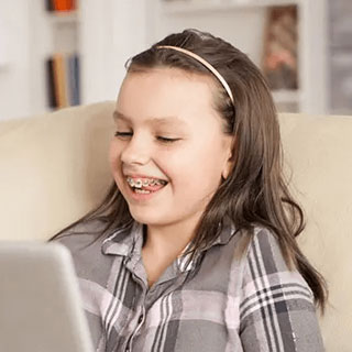 Teen Girl smiling using laptop