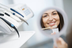 Cheerful young girl is visiting dental clinic and looking at reflection