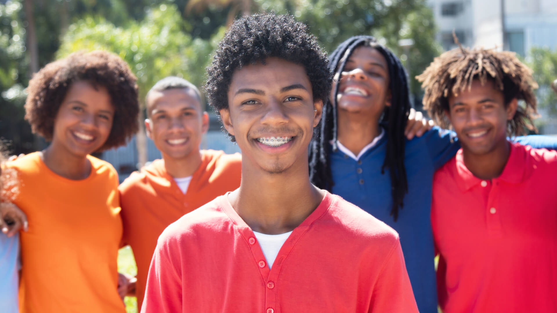 Cool young man with braces with group of friends in the city